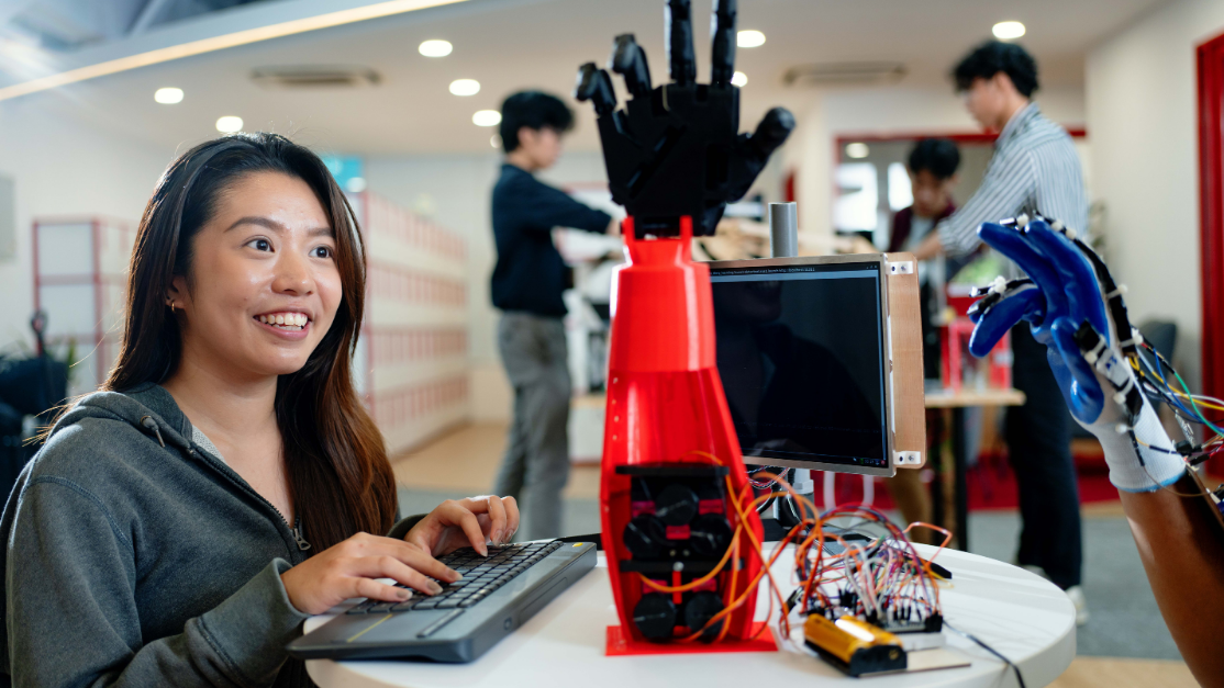student working on a robotic arm