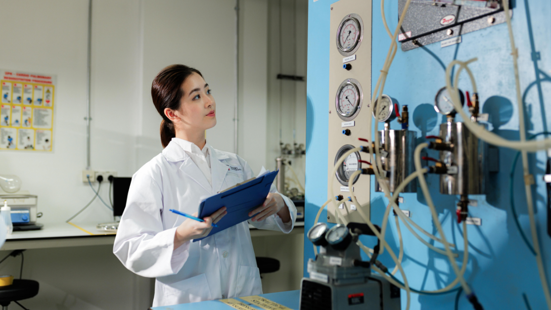 female student checking on a fluid engineering machine