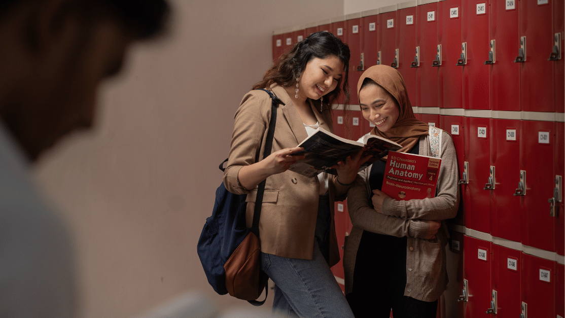 Taylor's College students are looking at textbook. 