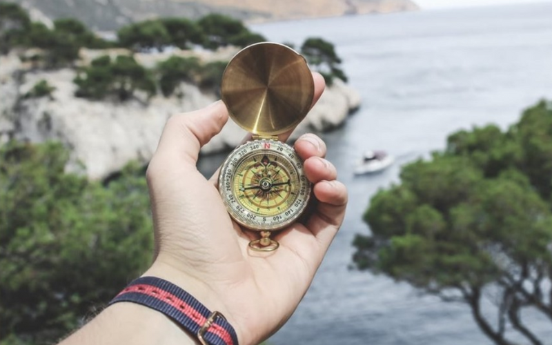 Hand holding a compass