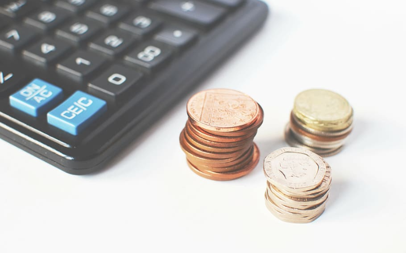 Coins stacked near a calculator