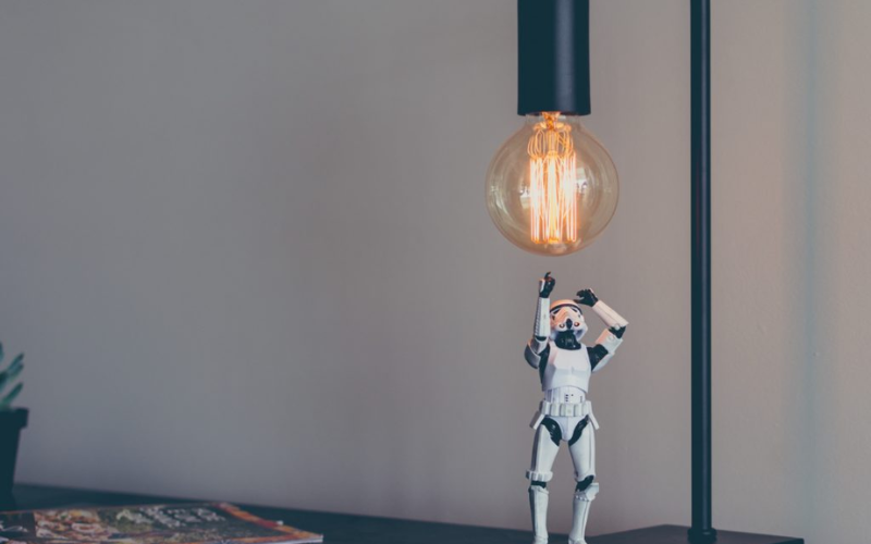 Figurine reaching for a lightbulb