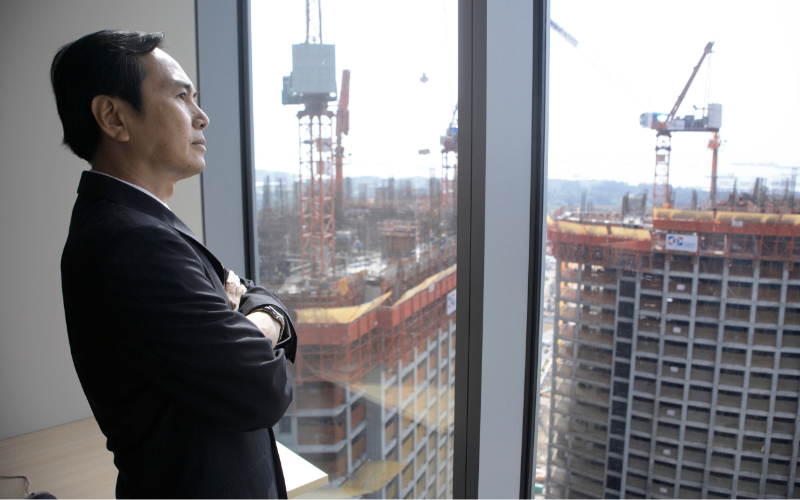 Businessman with arms crossed staring out of office window
