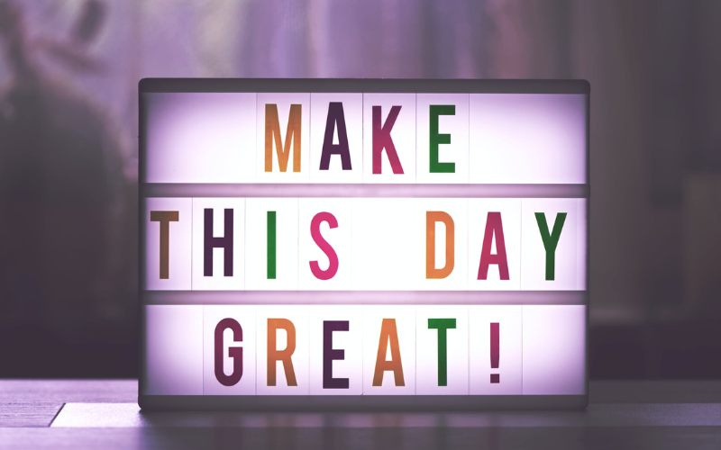 A sign saying "Make this day great!"