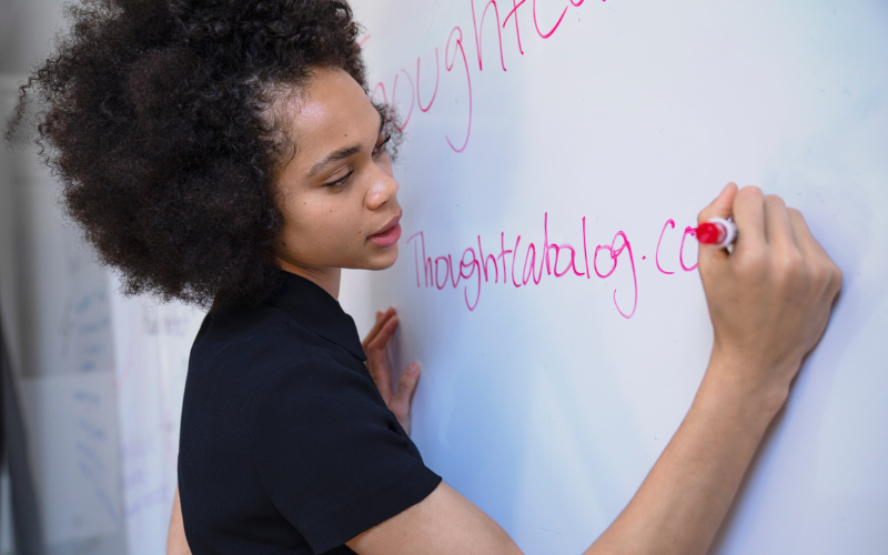 A girl is writng on the whiteboard