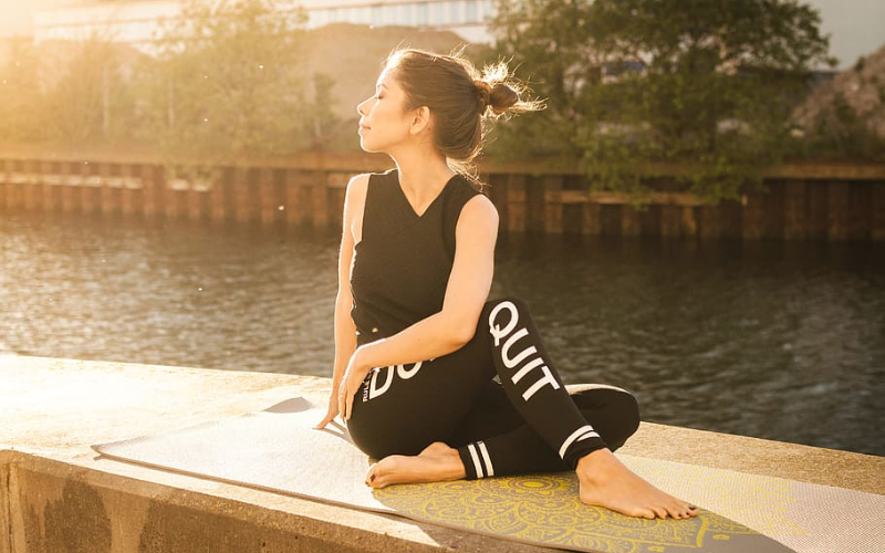 girl doing yoga near a lake