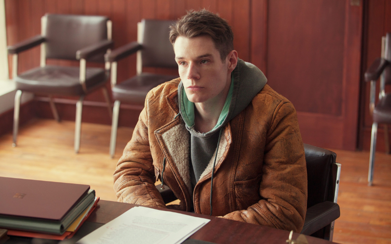 guy sitting down at a table with documents