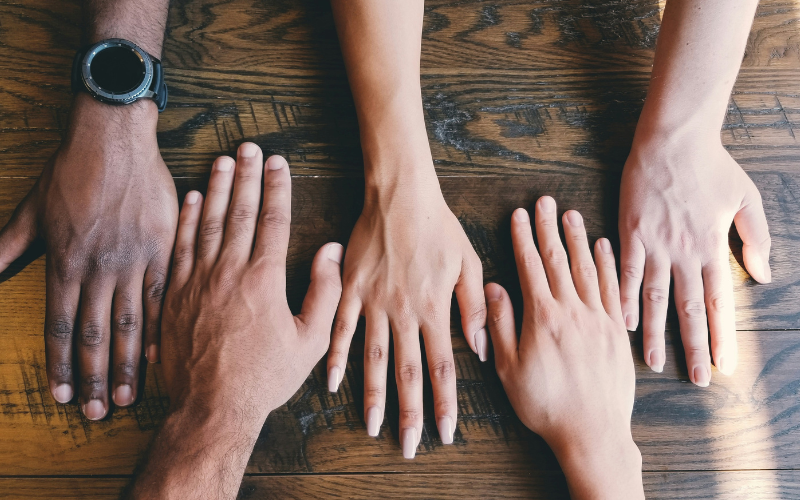 Picture of different hands on a table