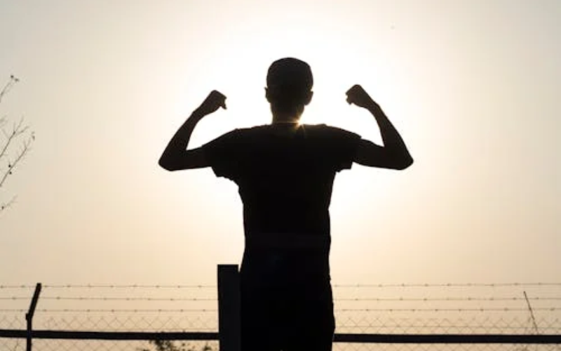 person flex posing towards the sun