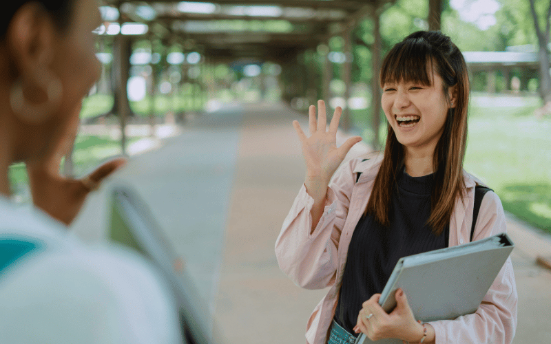Girl smiling and wave at her friend