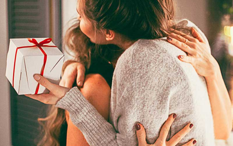 daughter hugging mother after gifting present