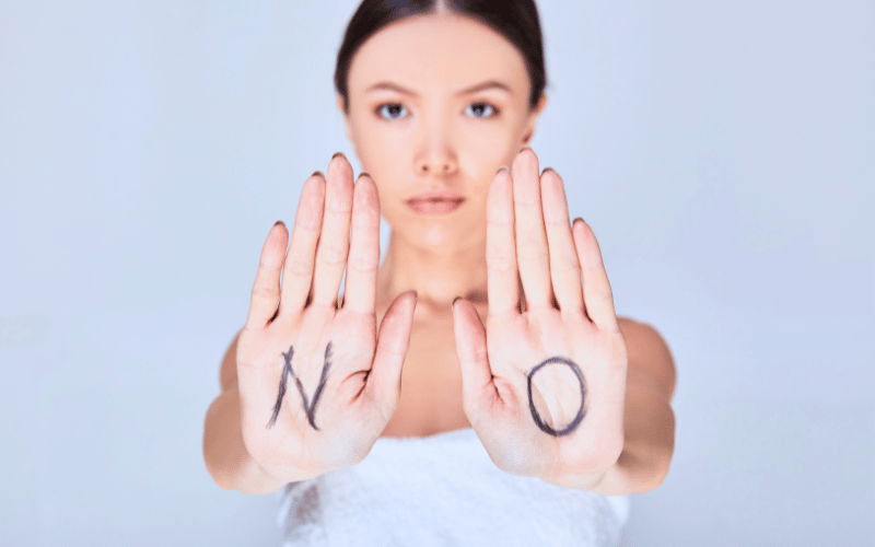 Woman holding her hands up with the Letter 'N' and 'O' written on