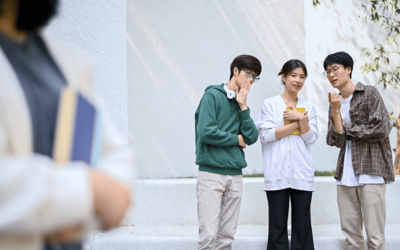 People talking and pointing at someone