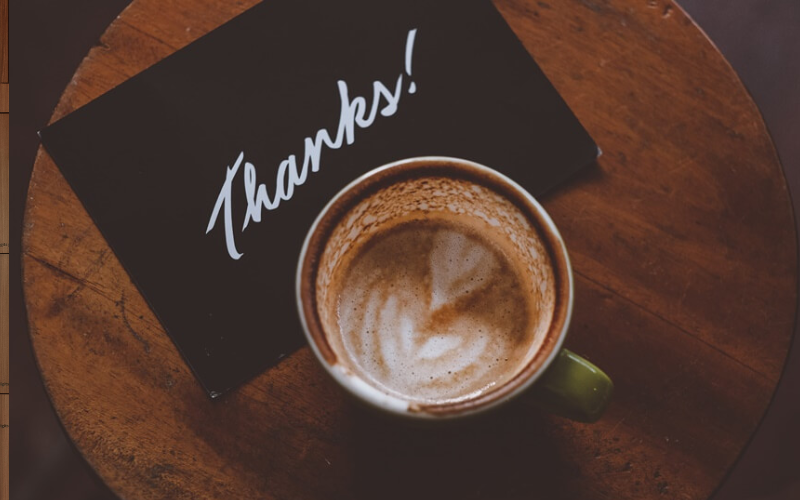 Coffee and the word "Thanks" on a table