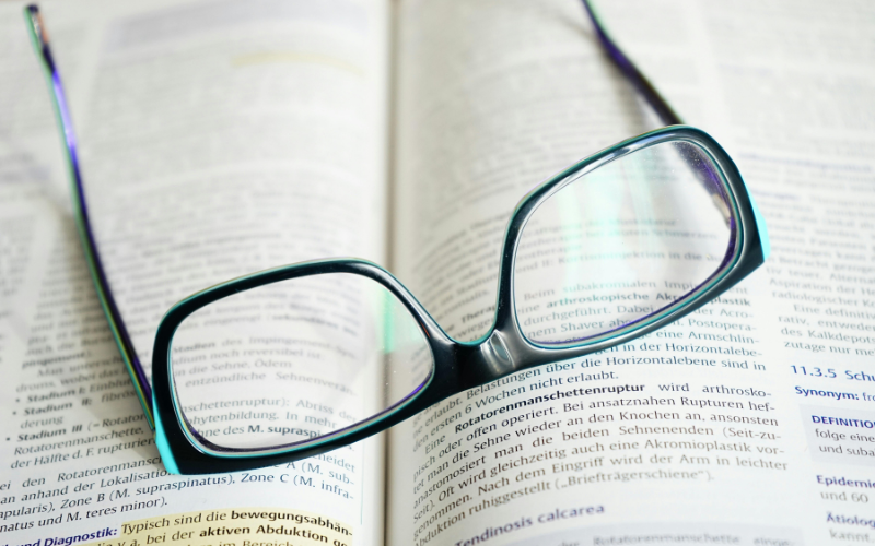 Picture of a pair of glasses laid on top of a book