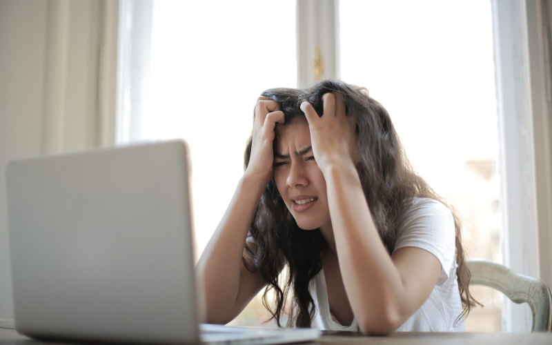 Woman looking at laptop in frustration