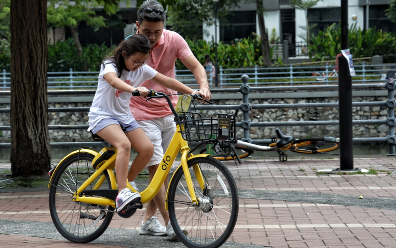 Dad teaching daughter to ride bicycle