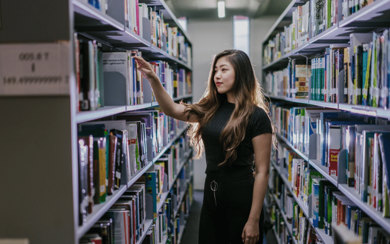 Girl checking out books on the shelves