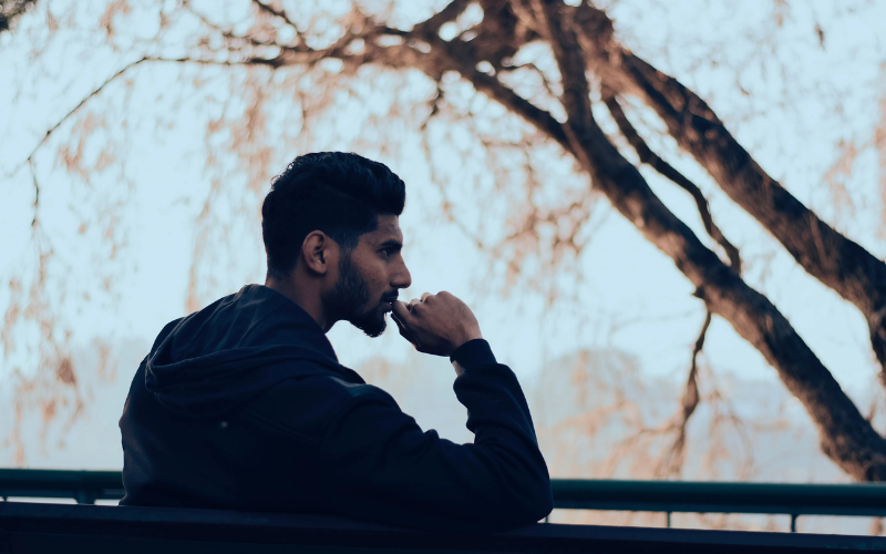 man sitting on a bench with a thinking pose