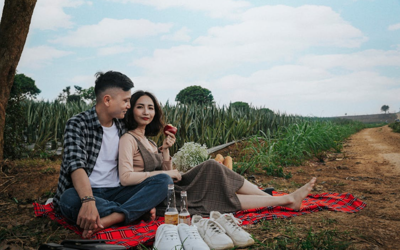 Woman leaning on Man while on a picnic