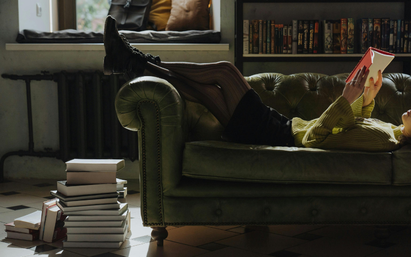 Stack of books on sofa in dark