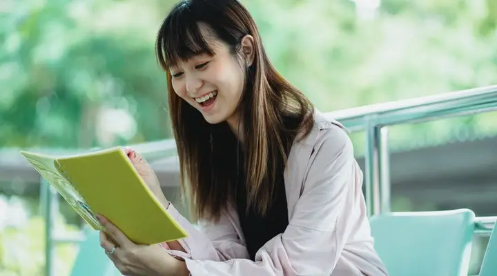 Girl smiling while holding a book