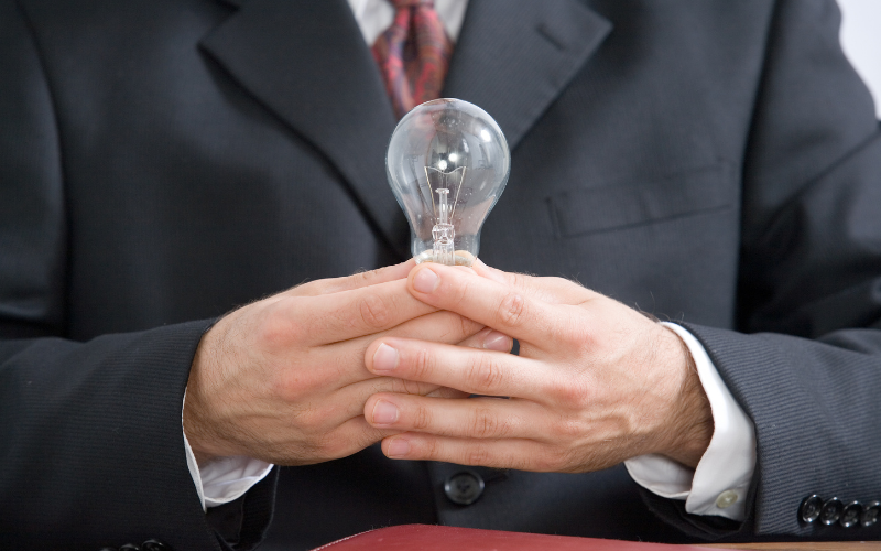 businessman holding a light bulb