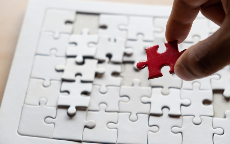 hand placing red puzzle piece