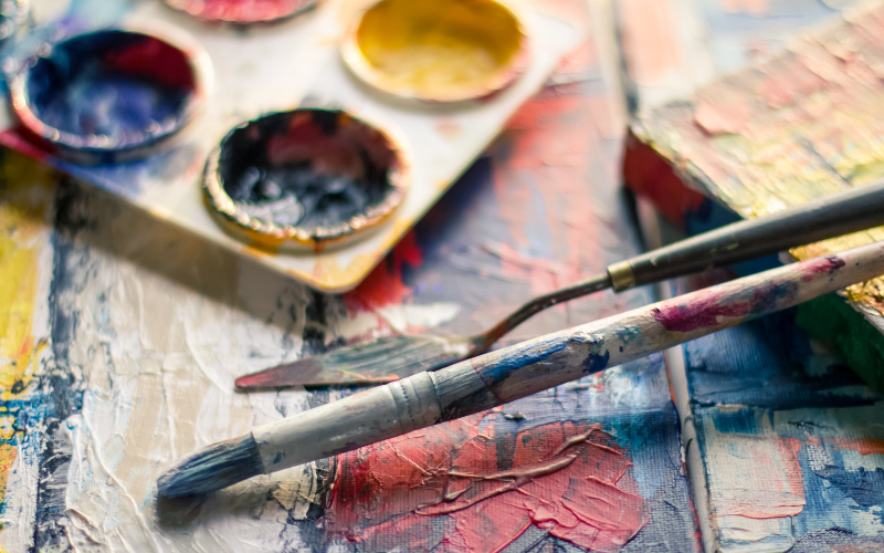 Paint palette with paint brushes around it