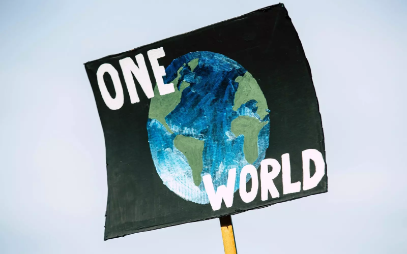 sign with a picture of earth and words "one world"