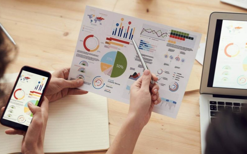 Phone, Laptop and a Piece of Paper displaying various statistics