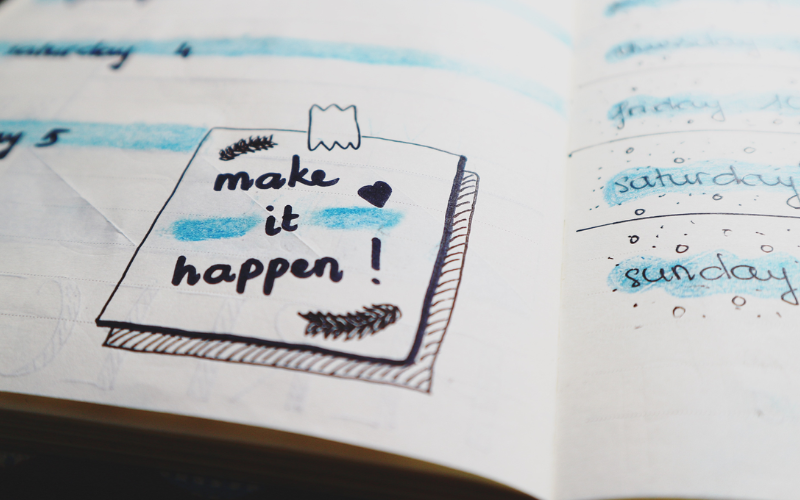 "Make it happen" written on a book