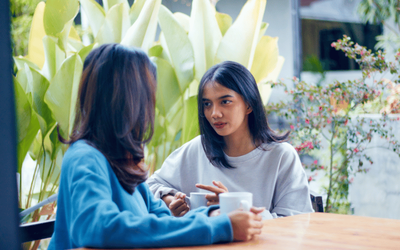 Two people talking over drinks