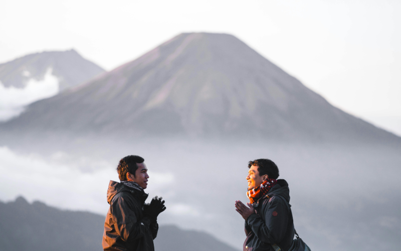 Two people talking with a mountain view