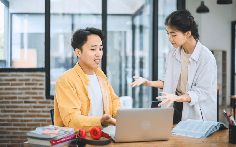 Two person having an intense discussion in front of the laptop