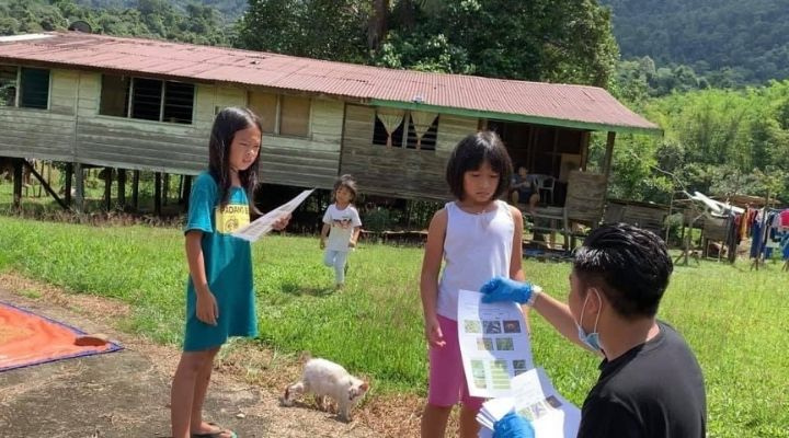Cikgu Nazmi passing learning materials to his students during the lockdown.