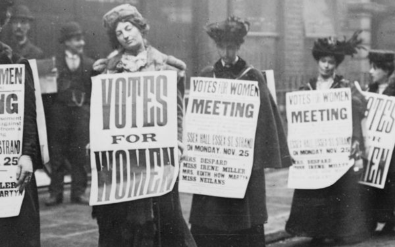 A group of women took a "votes for women" poster