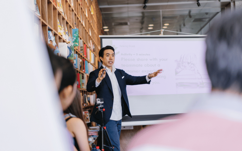 A guy presents confidently in front of the audience