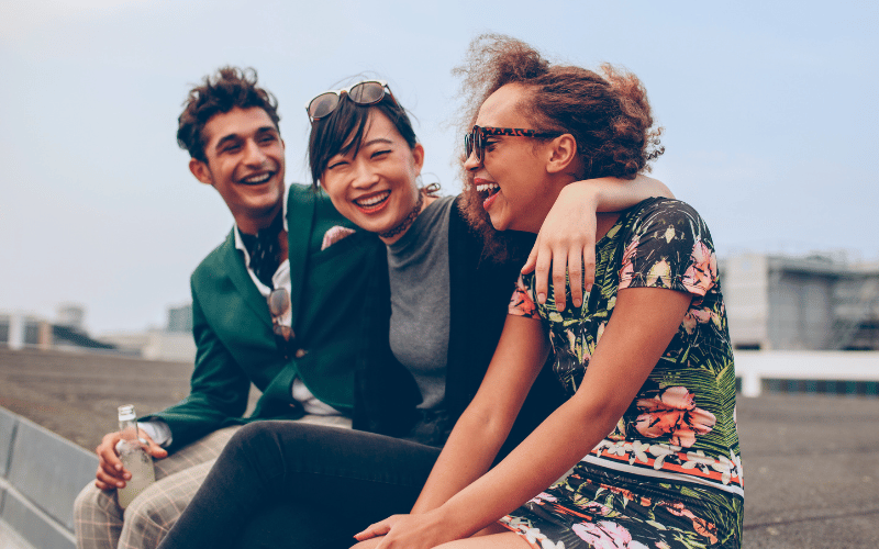 three international friends laugh together