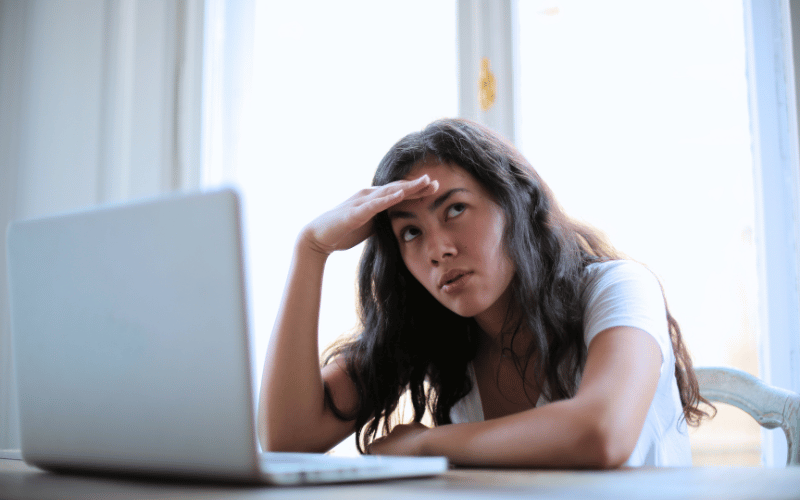 Asian lady looks irritated in front of her laptop