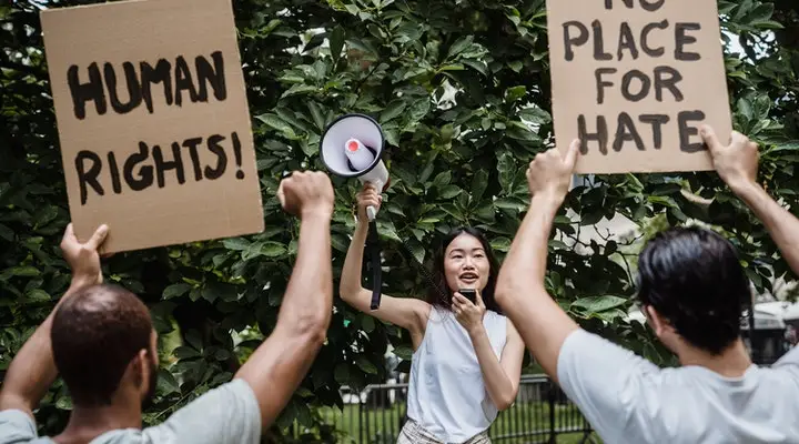 Woman using microphone speaker leading a rally protest