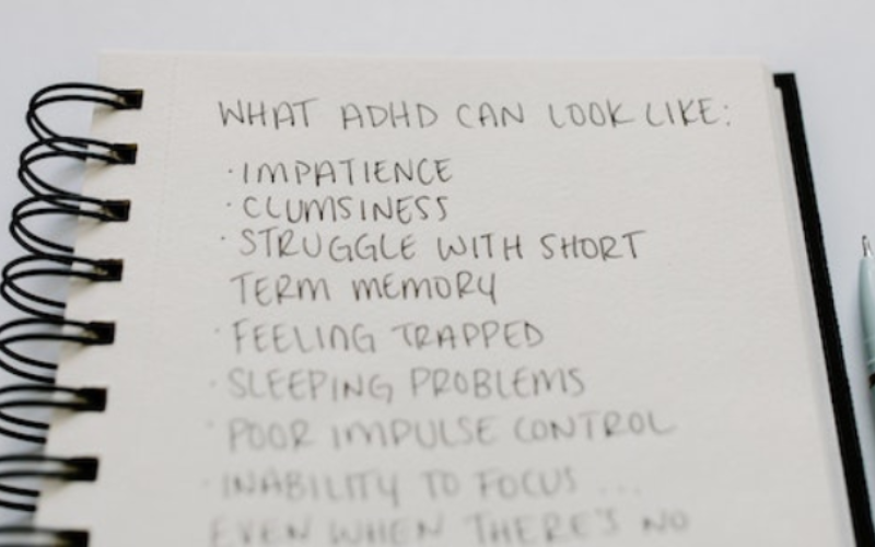 A notebook wrote "WHAT ADHD CAN LOOK LIKE"
