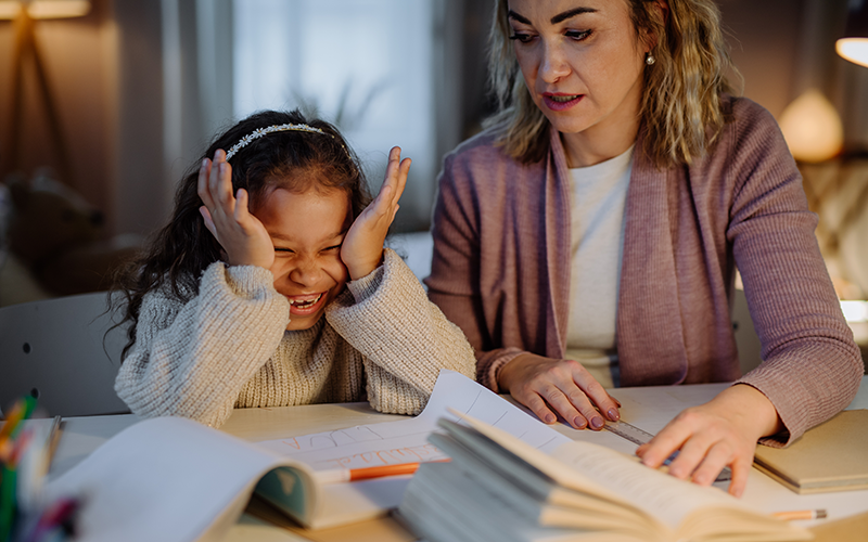 Adult woman teaching a girl in evening study