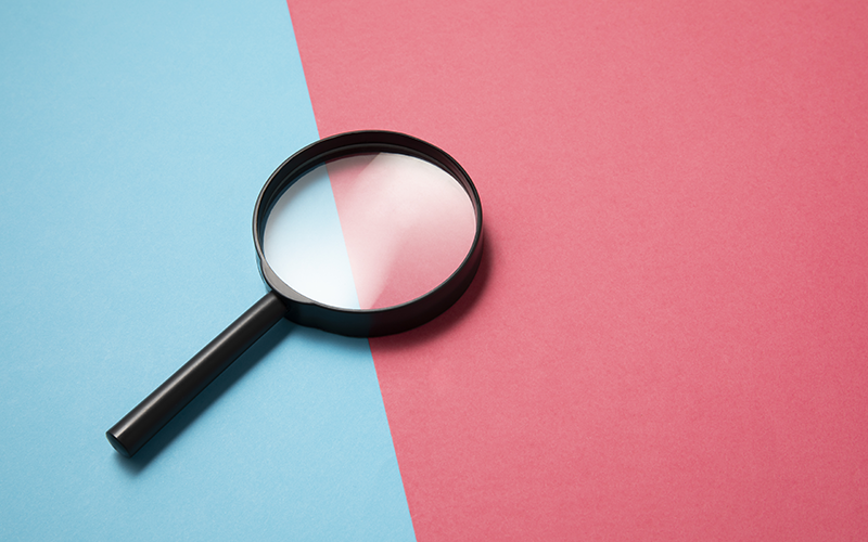 Magnifying glass against bi-coloured background
