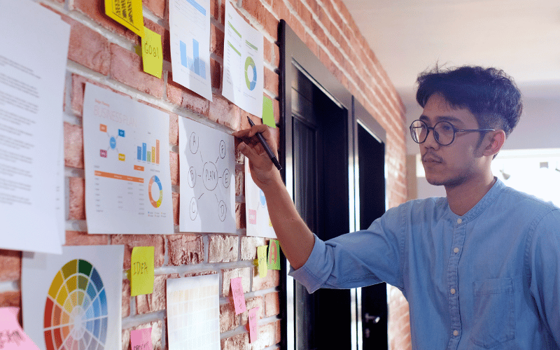 A man looking at printed diagrams and charts on the wall