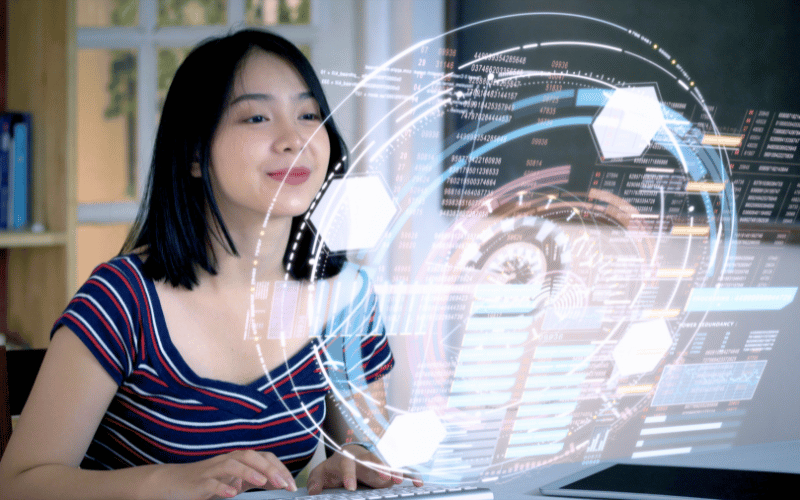 A lady student types on a keyboard looking at holographic projection