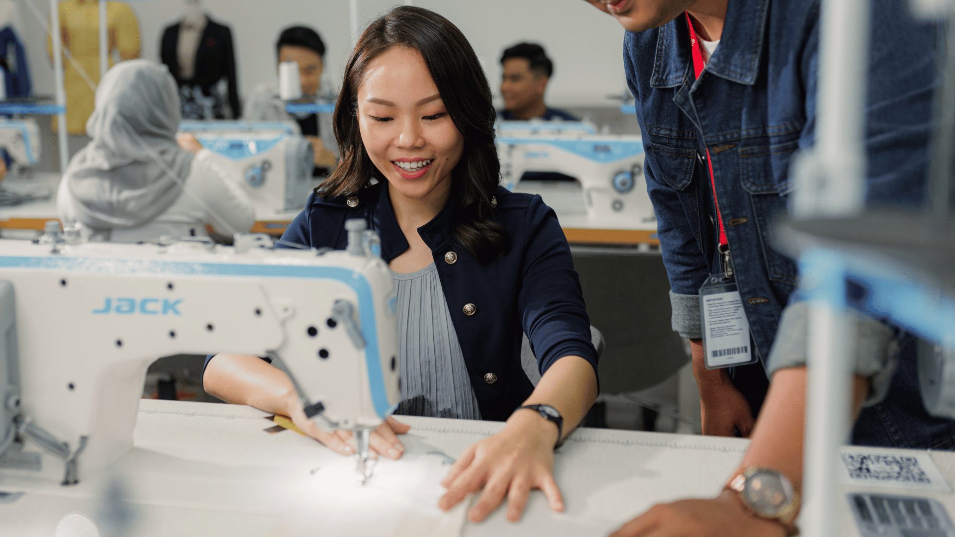 Female student is sewing under an adult supervision