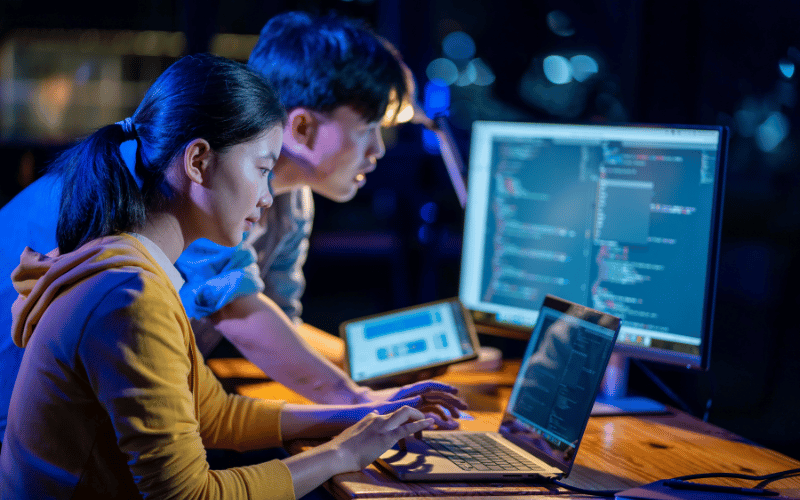 A lady and a man working on coding project together