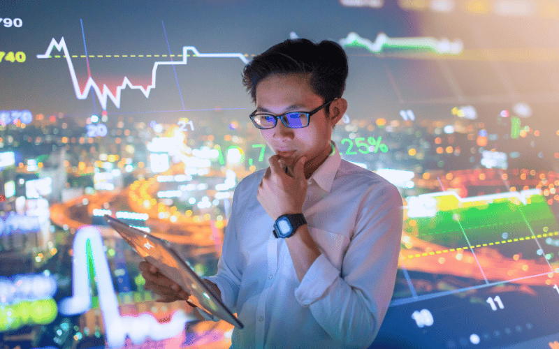 A man looking intently at his screen with cryptocurrency analysis as background