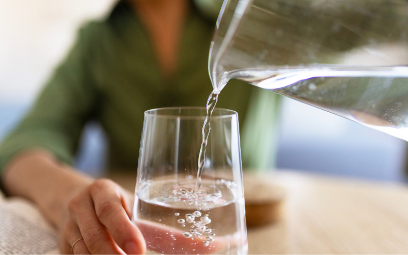 Person pouring water into a glass